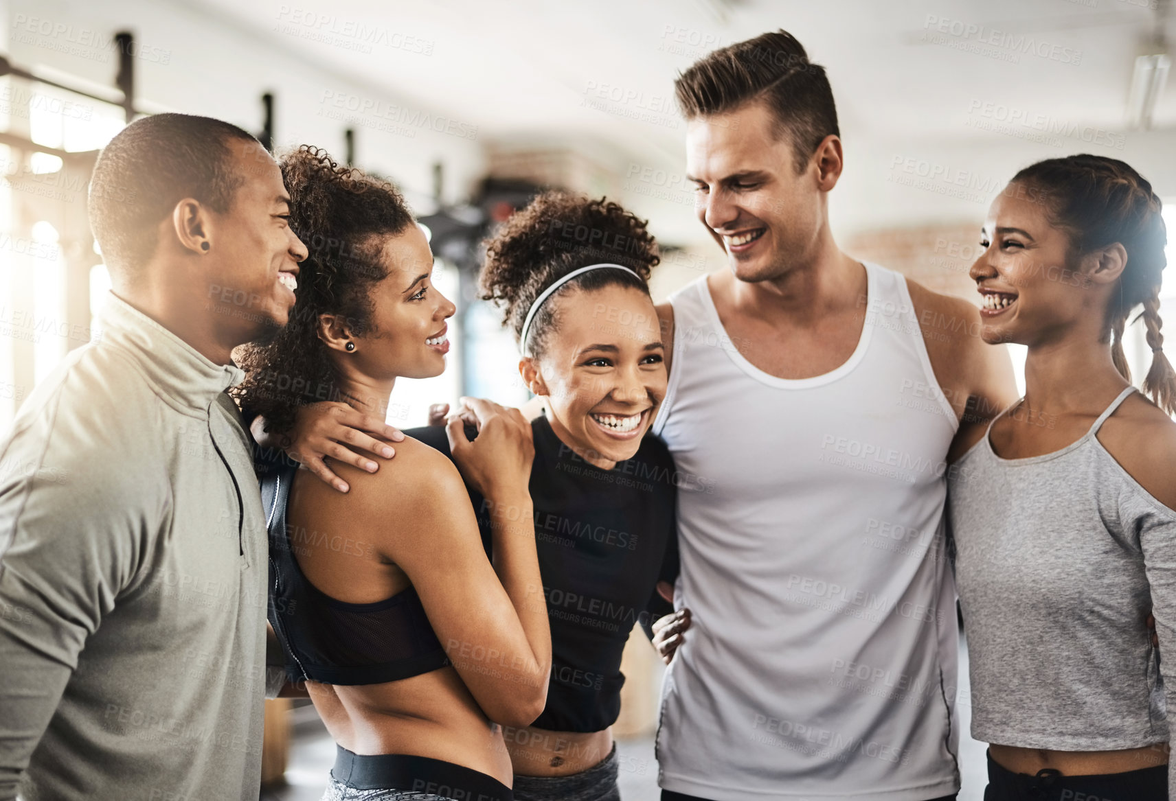 Buy stock photo Shot of a group of happy young people working out together in a gym