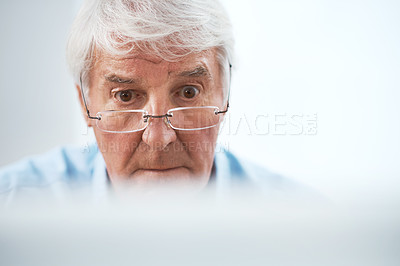 Buy stock photo Cropped shot of a handsome senior businessman working on his computer at home