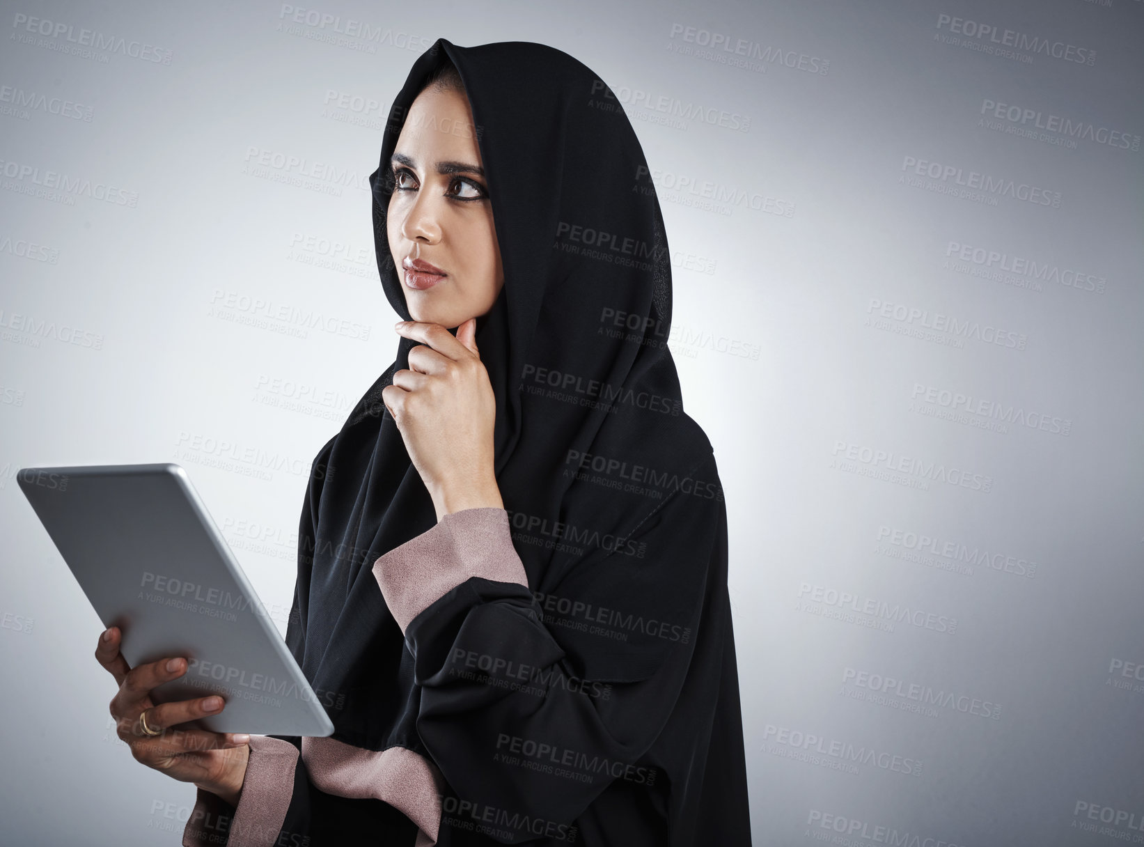 Buy stock photo Cropped shot of an attractive young businesswoman using her tablet while standing against a grey background