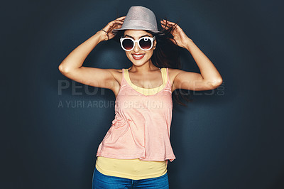 Buy stock photo Studio shot of an attractive and fun loving young woman posing against a dark background