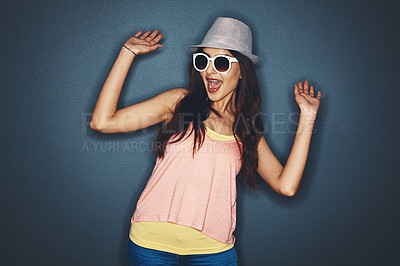 Buy stock photo Studio shot of an attractive and fun loving young woman posing against a dark background