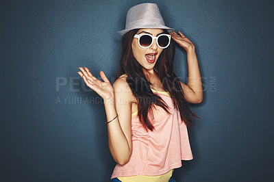 Buy stock photo Studio shot of an attractive and fun loving young woman posing against a dark background
