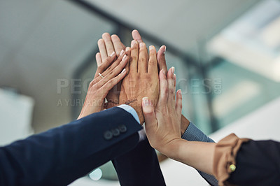 Buy stock photo Closeup of a group of unrecognizable businesspeople holding up their hands for a high five in the office during the day