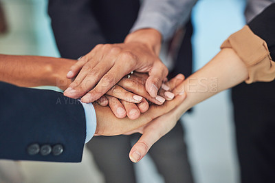 Buy stock photo Closeup of a group of unrecognizable businesspeople forming a huddle with their hands while standing in the office during the day