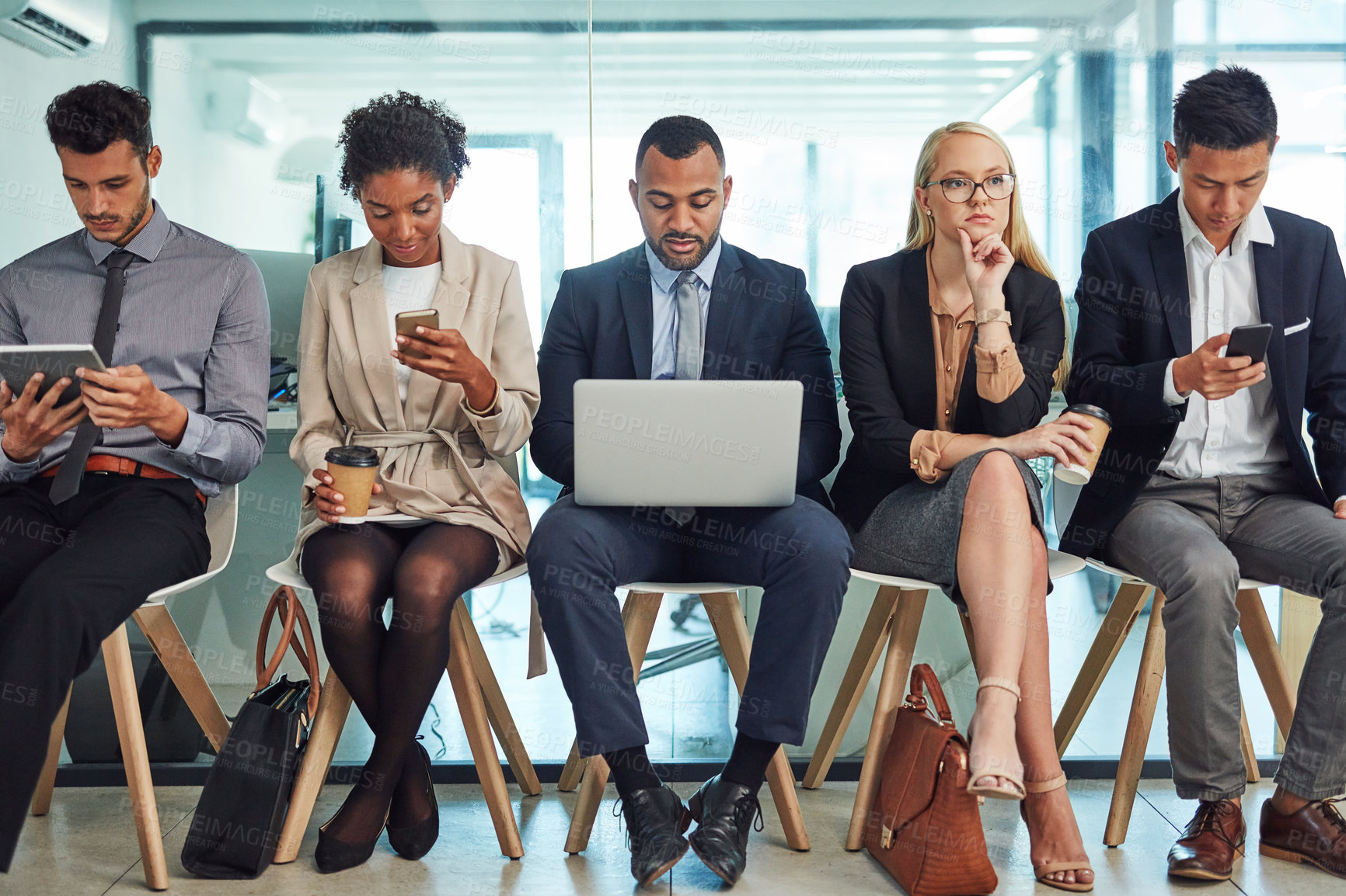 Buy stock photo Business people, row and waiting room with technology for interview, career or job opportunity at office. Young, group or employees on chairs with laptop, tablet or phone for company search or offer