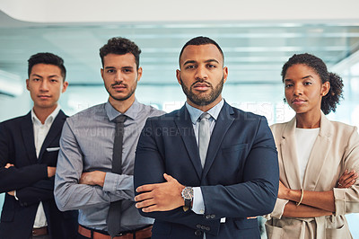 Buy stock photo Portrait of a group of confident young businesspeople standing with their arms folded inside of the office at work during the day