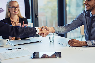 Buy stock photo Cropped shot of a young businessman shaking hands with a colleague during a meeting in a modern office