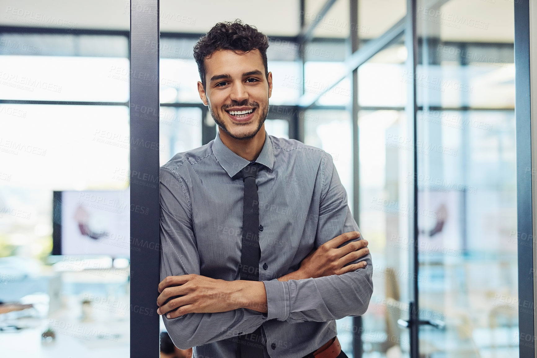 Buy stock photo Shot of a confident young businessman working in a modern office