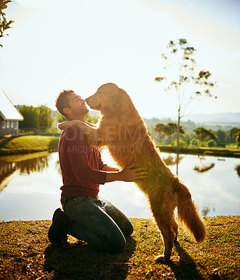 Buy stock photo Full length shot of a handsome young man and his dog spending the day by a lake in the park