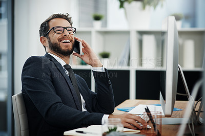 Buy stock photo Shot of a young businessman talking on a cellphone while working in an office
