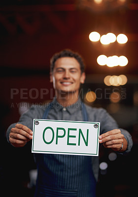 Buy stock photo Portrait of a cheerful young business owner holding up a sign saying 