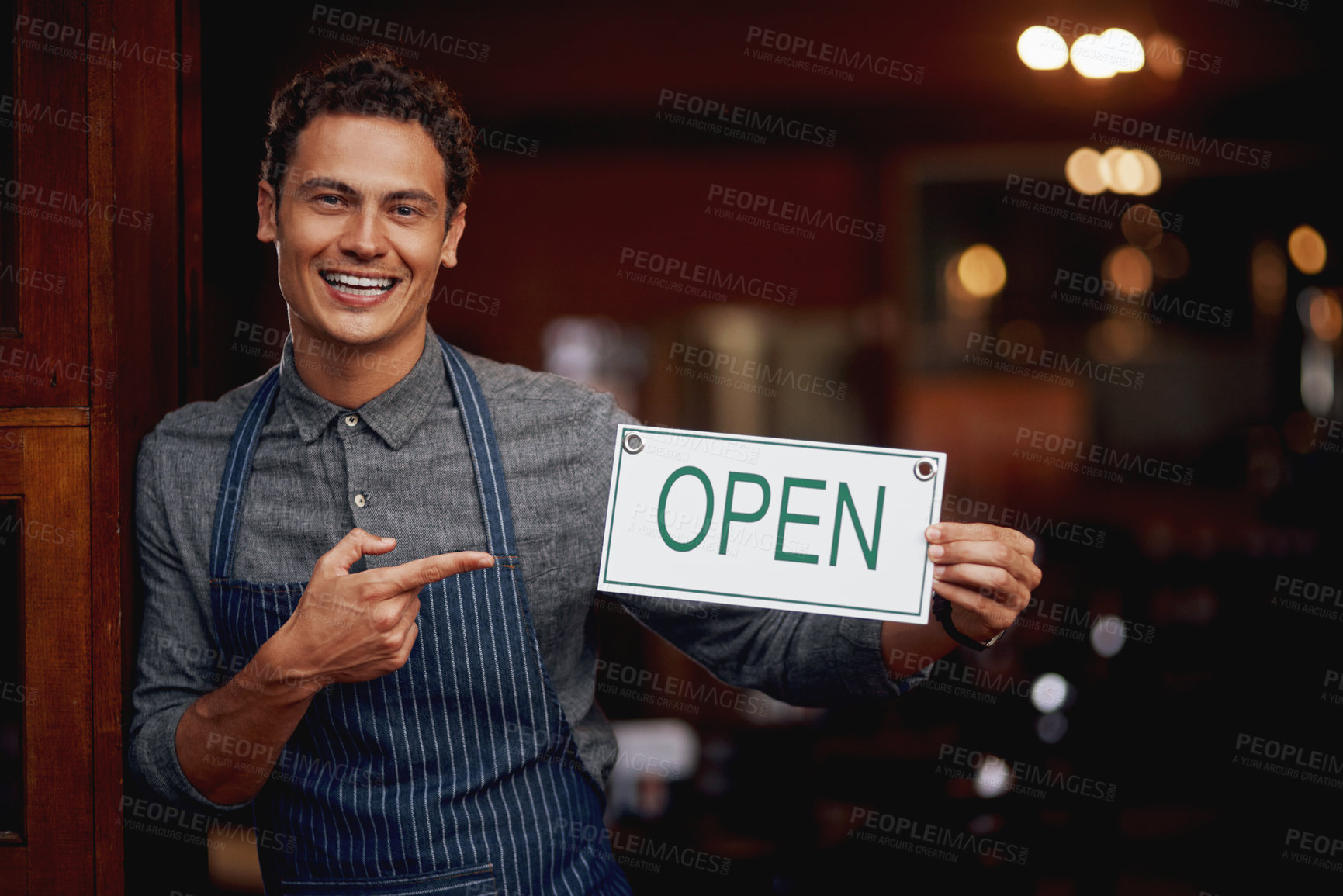 Buy stock photo Entrance, portrait and man with open sign for cafe, invite clients and coffee shop hours for customer service. Restaurant, male owner and board with message for hospitality, doorway or small business