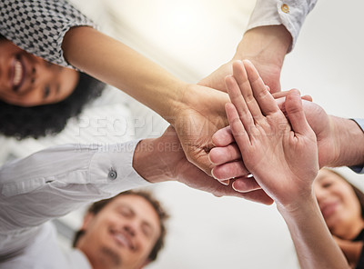 Buy stock photo Low angle shot of a group of colleagues joining hands in solidarity in a modern office