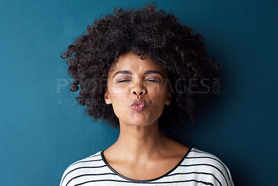 Buy stock photo Portrait, emoji and kissing with facial expression in studio for fun, relax and playful attitude on blue background. Pout, comic and goofy black woman with funny face, crazy and personality isolated