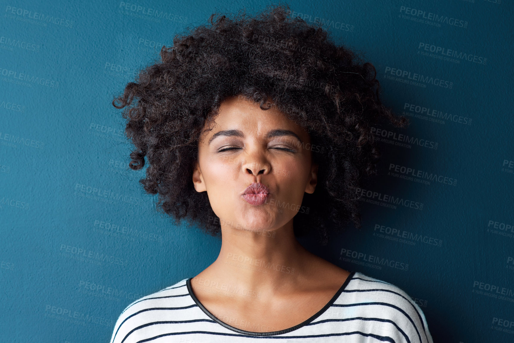 Buy stock photo Studio portrait of an attractive young woman pouting against a blue background