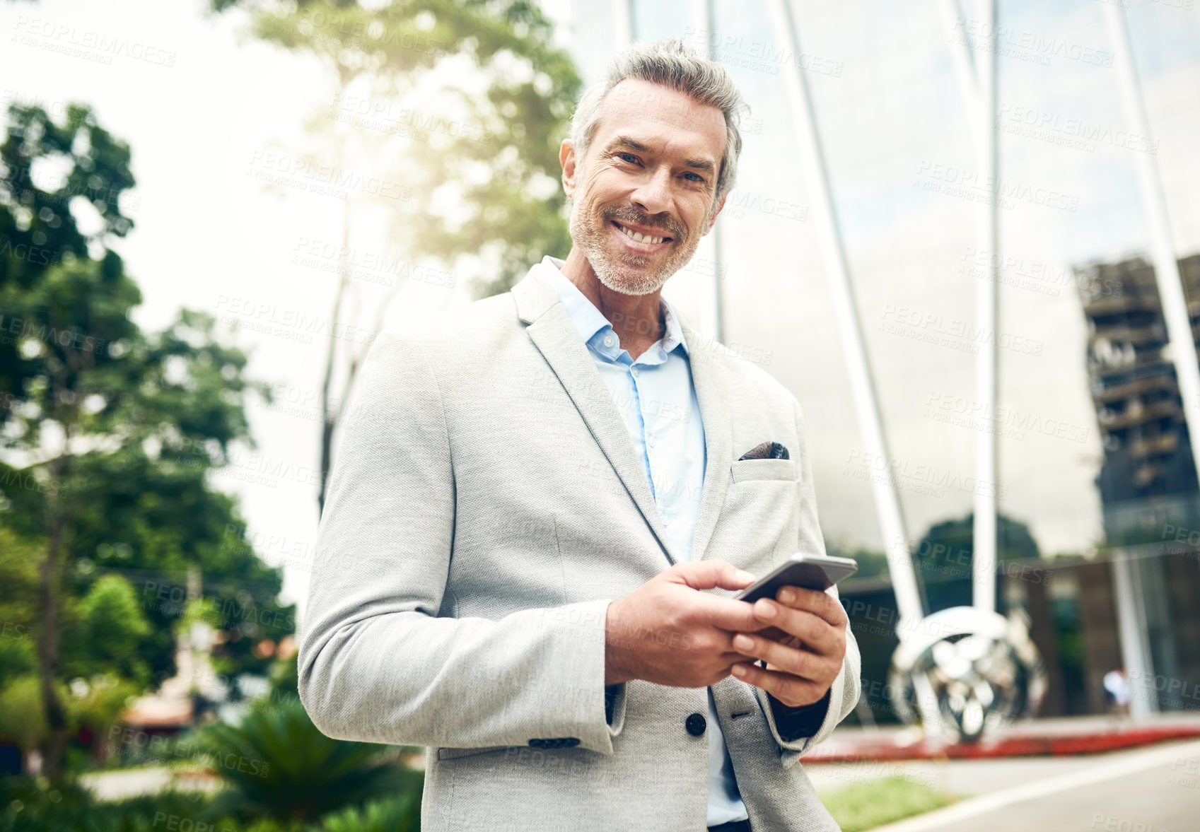 Buy stock photo Portrait of a mature businessman using a cellphone in the city