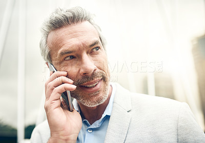 Buy stock photo Shot of a mature businessman talking on a cellphone in the city