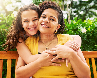 Buy stock photo Cropped portrait of an adorable young girl embracing her mother while out in the park