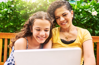 Buy stock photo Cropped shot of a young woman and her daughter using a laptop while sitting on a bench in the park