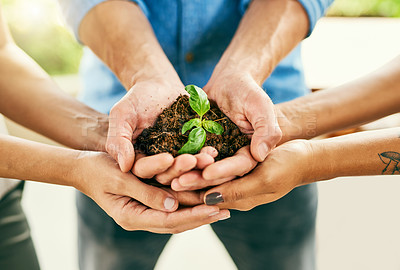 Buy stock photo Closeup shot of a group of people holding a plant growing out of soil