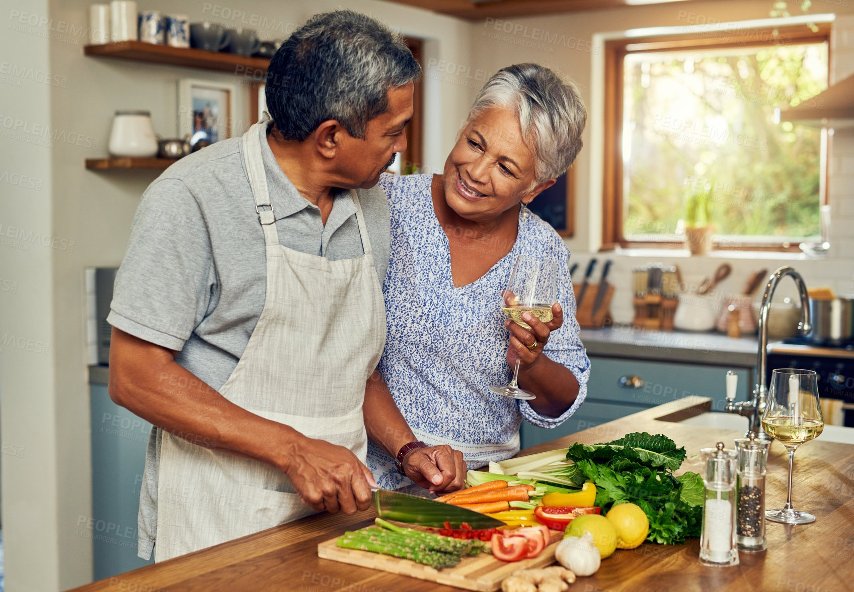 Buy stock photo Old couple in kitchen, wine and happiness, cooking healthy food together in home with vegetables. Drink, smile and senior woman with glass in house with man, meal prep and happy lunch in retirement.