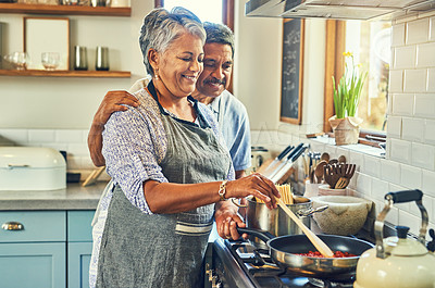 Buy stock photo Shot of a happy mature couple cooking a meal together at home