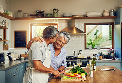 Buy stock photo Shot of a happy mature couple cooking a meal together at home