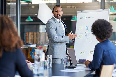 Buy stock photo Shot of a young businessman giving a presentation to his colleagues in an office