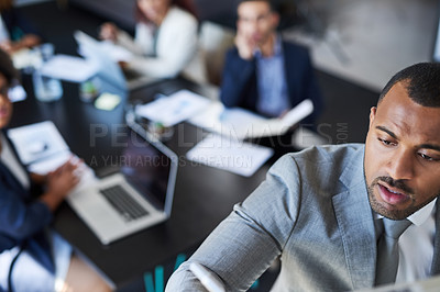 Buy stock photo Shot of a young businessman giving a presentation to his colleagues in an office