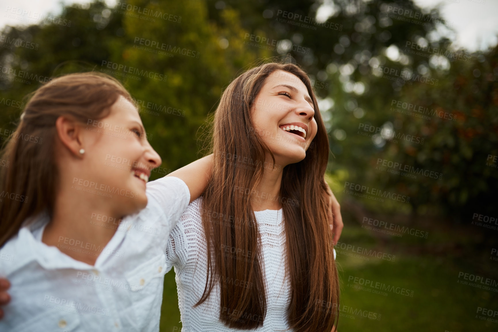 Buy stock photo Cropped shot of two young sisters enjoying their time together in the park