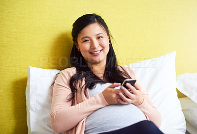 Buy stock photo Portrait of a pregnant woman using a cellphone at home