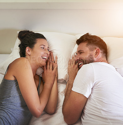 Buy stock photo Cropped shot of a young attractive couple lying in bed together at home