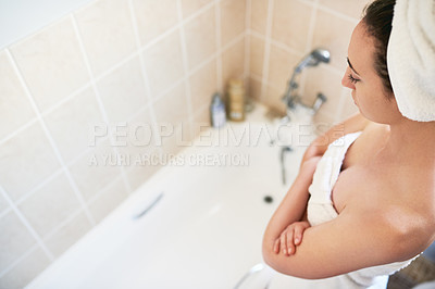 Buy stock photo High angle shot of a beautiful young woman getting ready to take a bath at home
