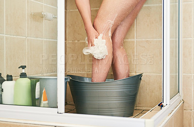 Buy stock photo Cropped shot of an unrecognizable woman washing in a bucket that has been placed in the shower at home