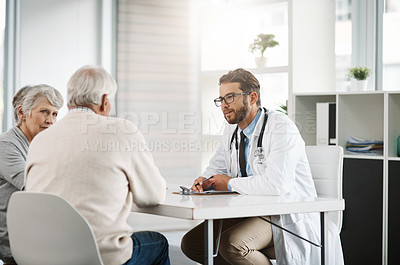 Buy stock photo Cropped shot of a confident young male doctor consulting a mature patient inside of the doctor's office