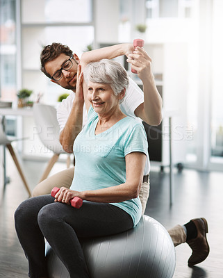 Buy stock photo Cropped shot of a young male physiotherapist working with a senior female patient