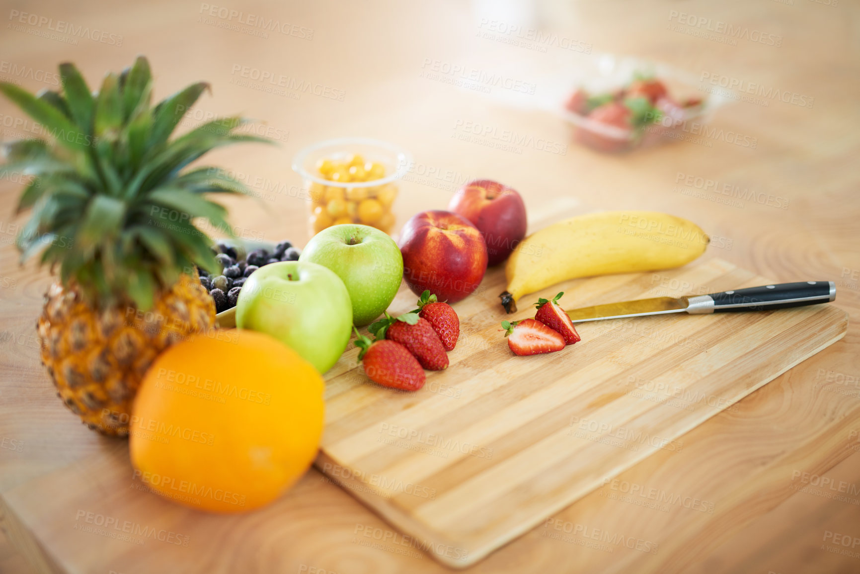 Buy stock photo Shot of fresh fruit on a chopping board in the kitchen