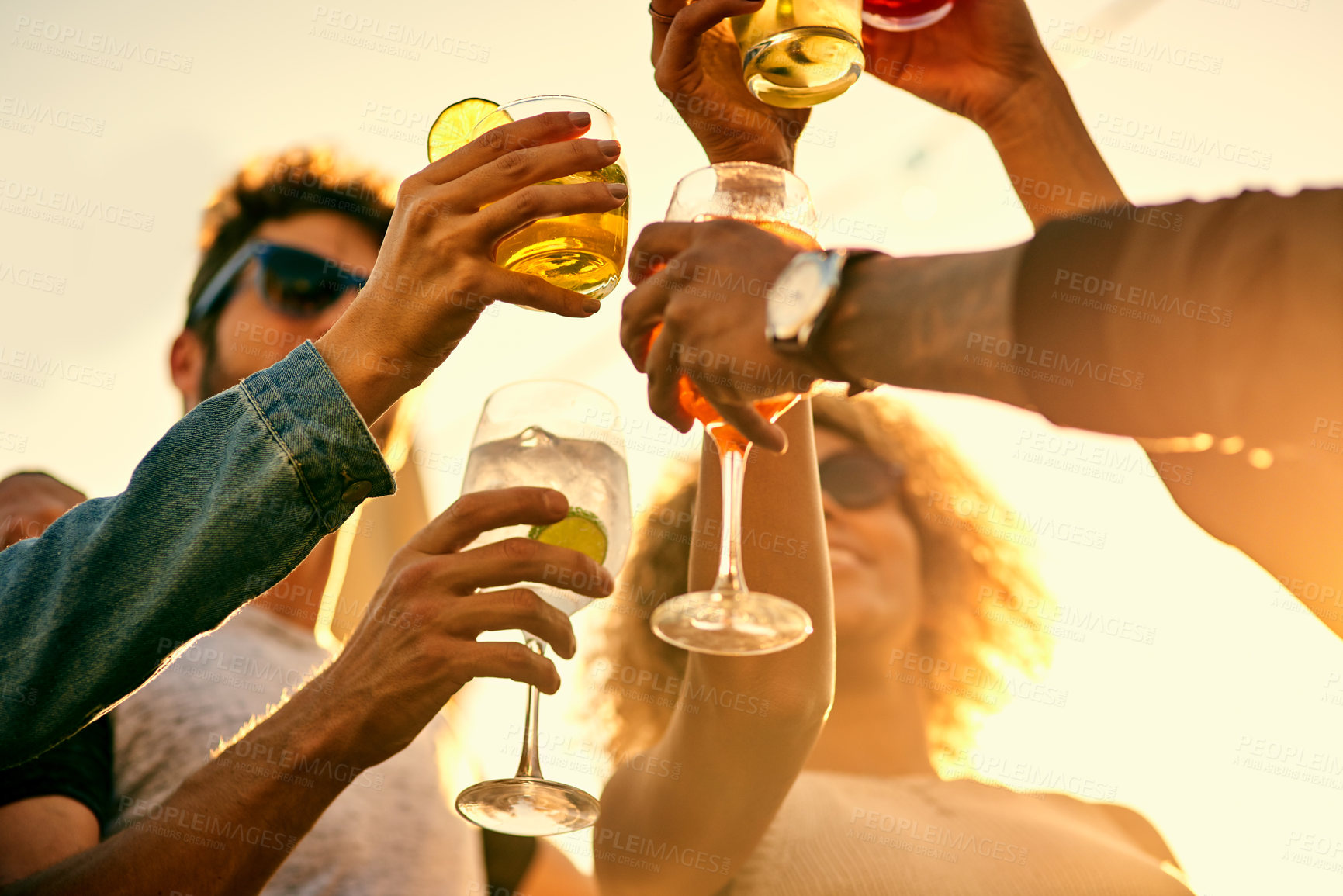 Buy stock photo Low angle shot of a group of young friends having a drink and spending the day outside on a rooftop
