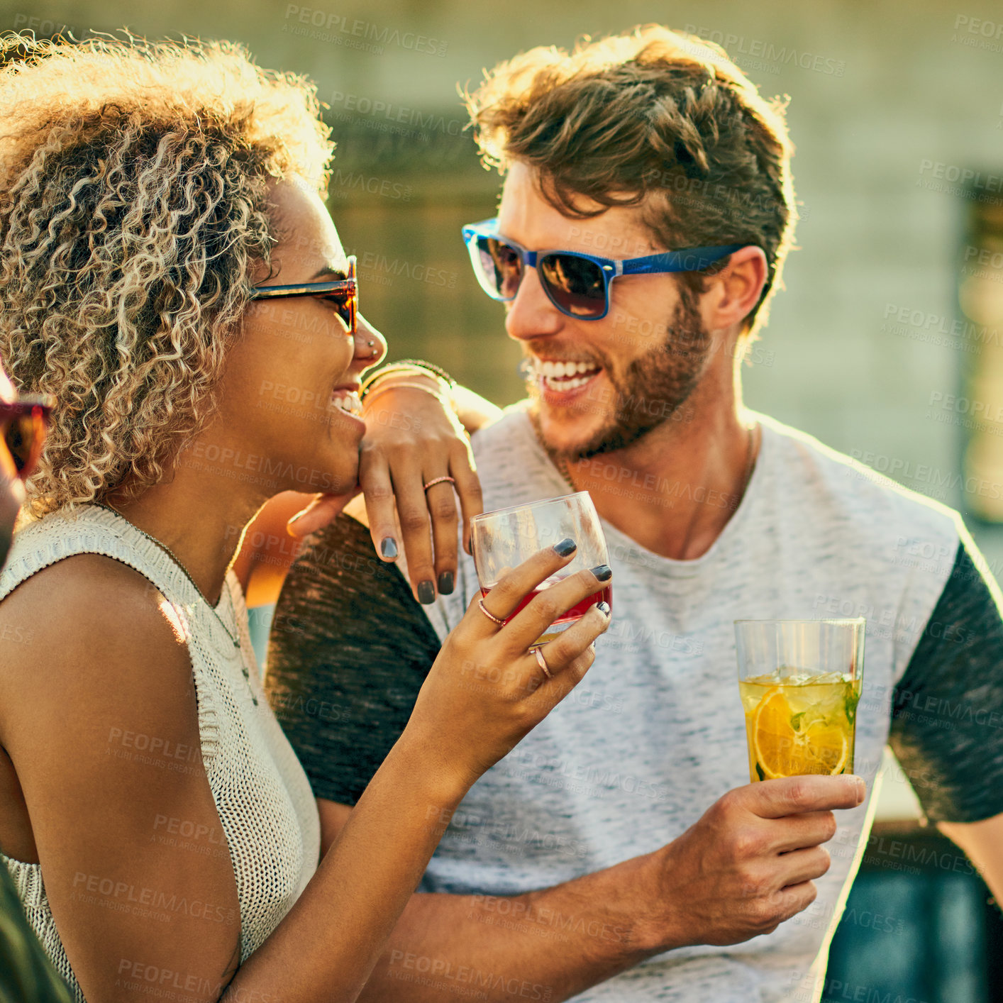 Buy stock photo Cropped shot of an attractive young couple having a drink and spending the day outside on a rooftop