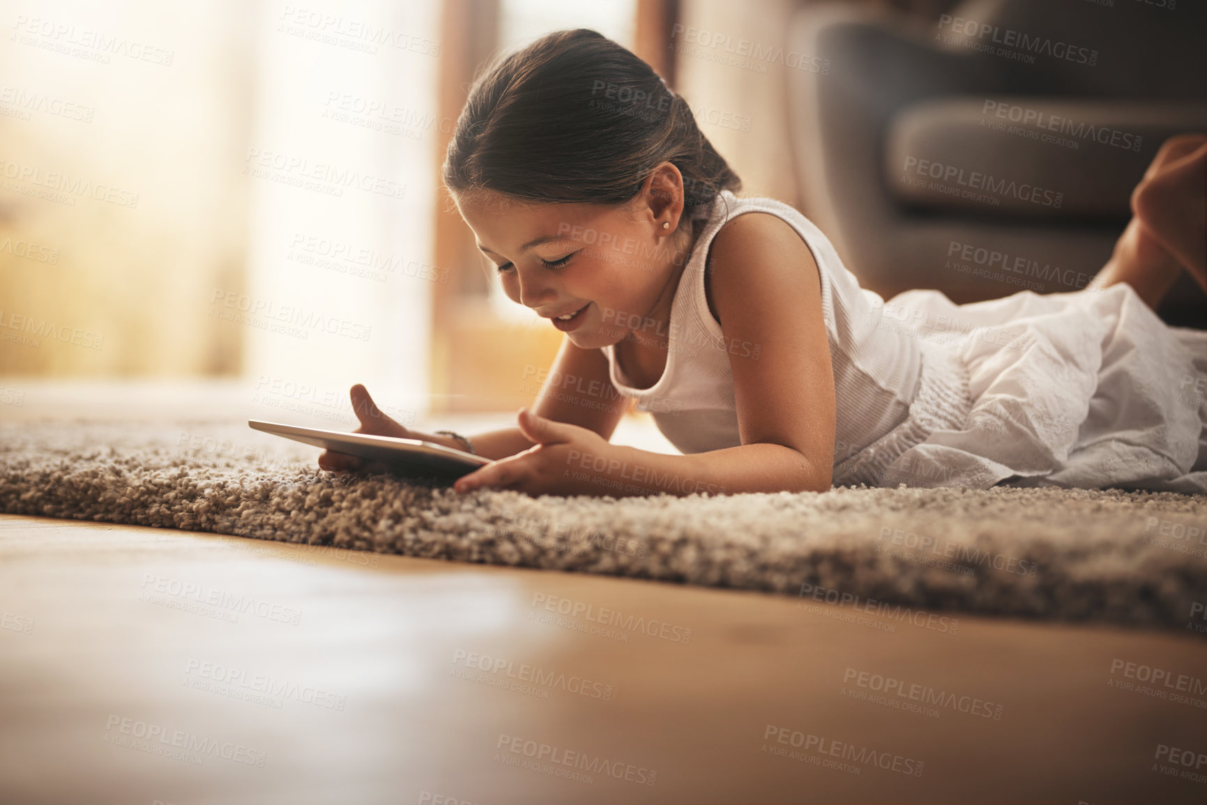 Buy stock photo Shot of an adorable little girl using a digital tablet on the floor at home