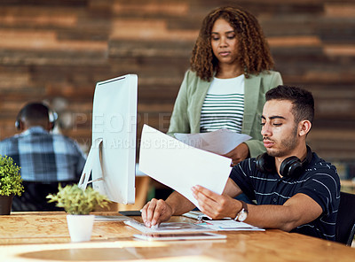 Buy stock photo Shot of two young designers working together on a computer in an office