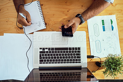 Buy stock photo High angle shot of an unrecognizable businessman working at his desk in an office