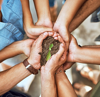 Buy stock photo Closeup shot of a group of people holding a plant growing in soil