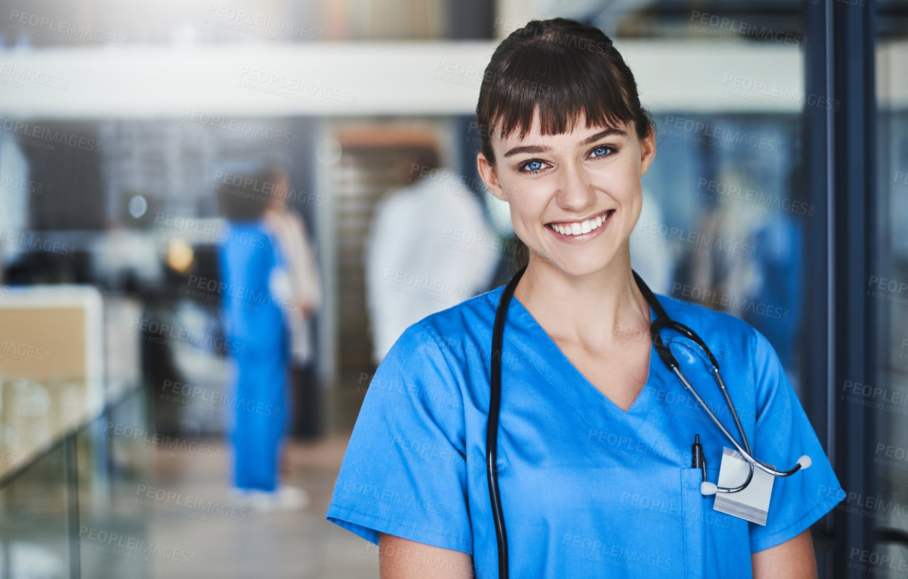 Buy stock photo Portrait of a confident young doctor working in a hospital with her colleagues in the background