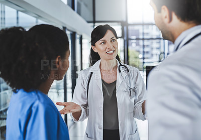 Buy stock photo Shot of a team of doctors having a discussion in a hospital
