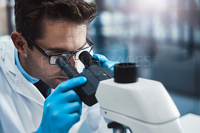 Buy stock photo Cropped shot of a young male scientist working in a lab with a microscope