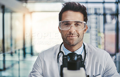 Buy stock photo Portrait of a young handsome male scientist working in a lab with a microscope