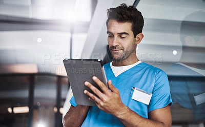 Buy stock photo Cropped shot of a young handsome male medical practitioner working in a hospital