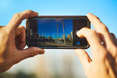 Buy stock photo Cropped shot of an unrecognizable man taking a photo of the city with his cellphone outside