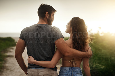 Buy stock photo Rearview shot of a young couple spending a romantic day at the beach